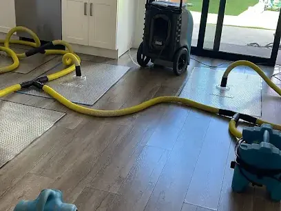 Air movers and a dehumidifier drying a kitchen floor