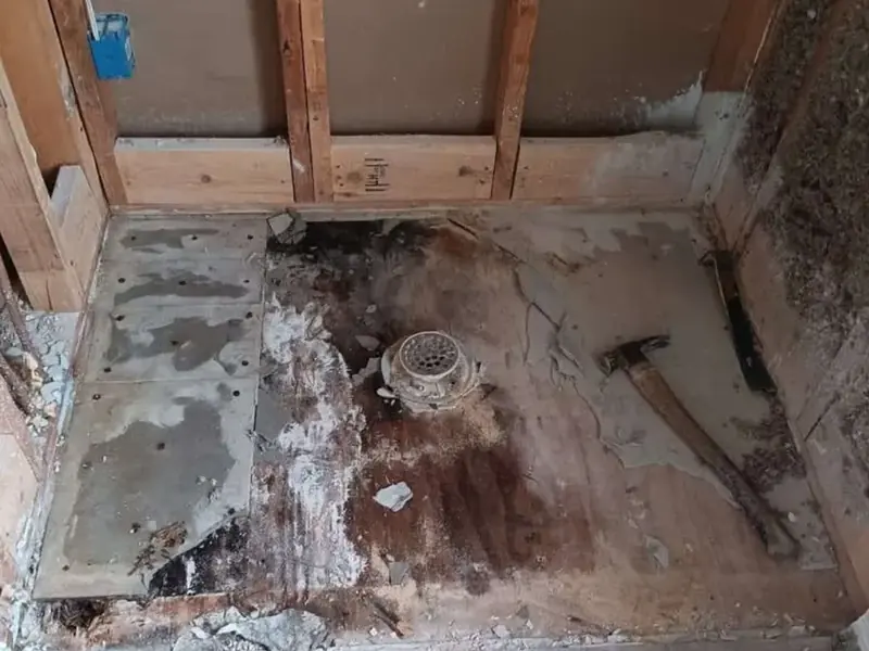 Tile shower wall opened to reach water damage behind it